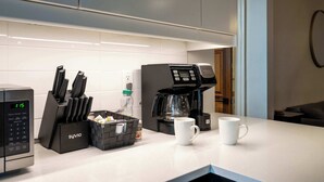 A modern kitchen with a coffee maker, knife block, and a digital clock. - Historic Retreat Gateway (Dayton)