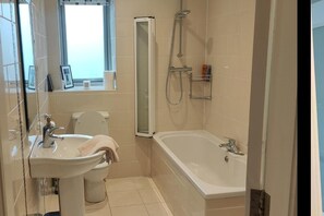 A bathroom with a toilet, sink, and bathtub. - Cozy City Escape in Galway (Galway)
