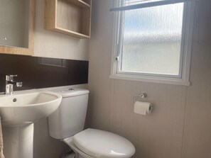 Een badkamer met toilet, wastafel en raam met uitzicht.
