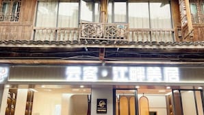 Un edificio de estilo tradicional con un interior moderno, que presenta una zona de recepción con sillas rojas y un cartel.