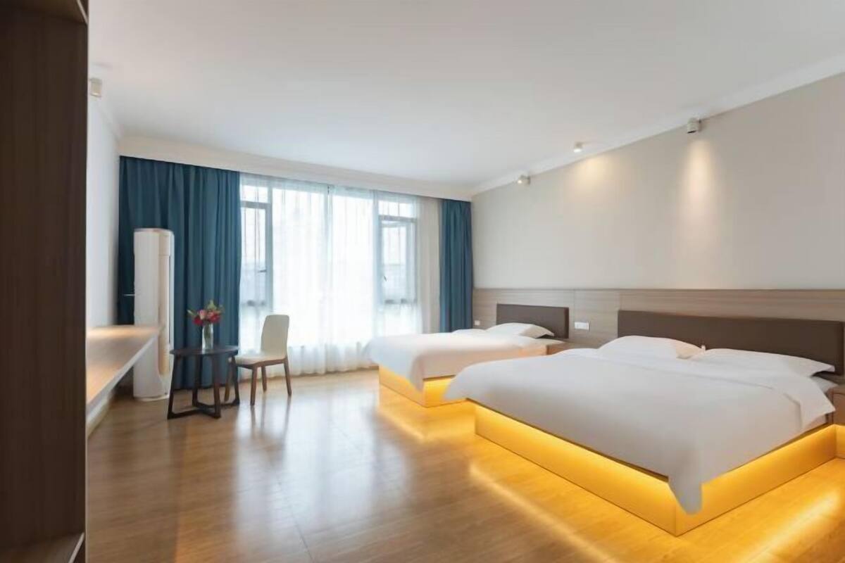 Habitación de hotel con dos camas, un escritorio y una silla.