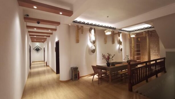 Un pasillo espacioso con suelo de madera y una zona de comedor con mesa y sillas de madera.