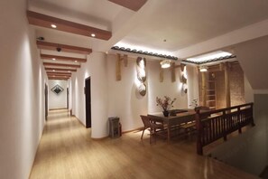 A spacious hallway with wooden flooring and a dining area with a wooden table and chairs. - Yunke Riverside Mercure (Liuzhou Sanjiang Drum Tower Fengyu Bridge) (Sanjiang)