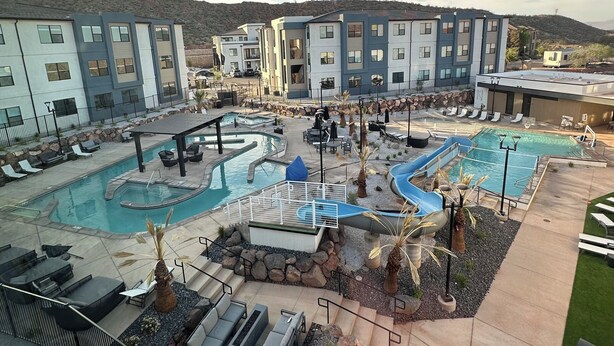 Ein Resort mit mehreren Schwimmbecken, Liegebereichen und modernen Gebäuden.