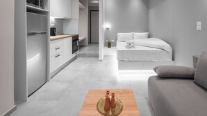 A modern, compact living space with a kitchenette, a sofa, and a small dining table. - Bitola, Nilie Hospitality MGMT (Thessaloniki)