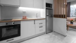 A modern kitchen with white cabinetry, a wooden countertop, and a built-in oven. - Bitola, Nilie Hospitality MGMT (Thessaloniki)