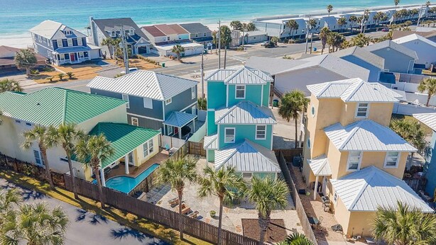 A coastal residential area with houses, a swimming pool, and a beach in the background. - Turquoise Tail (Panama City Beach)