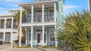 A two-story building with a balcony, a 'For Sale' sign, and a 'For Rent' sign. - Turquoise Tail (Panama City Beach)