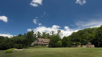 A large house with a spacious lawn and a wooden deck.