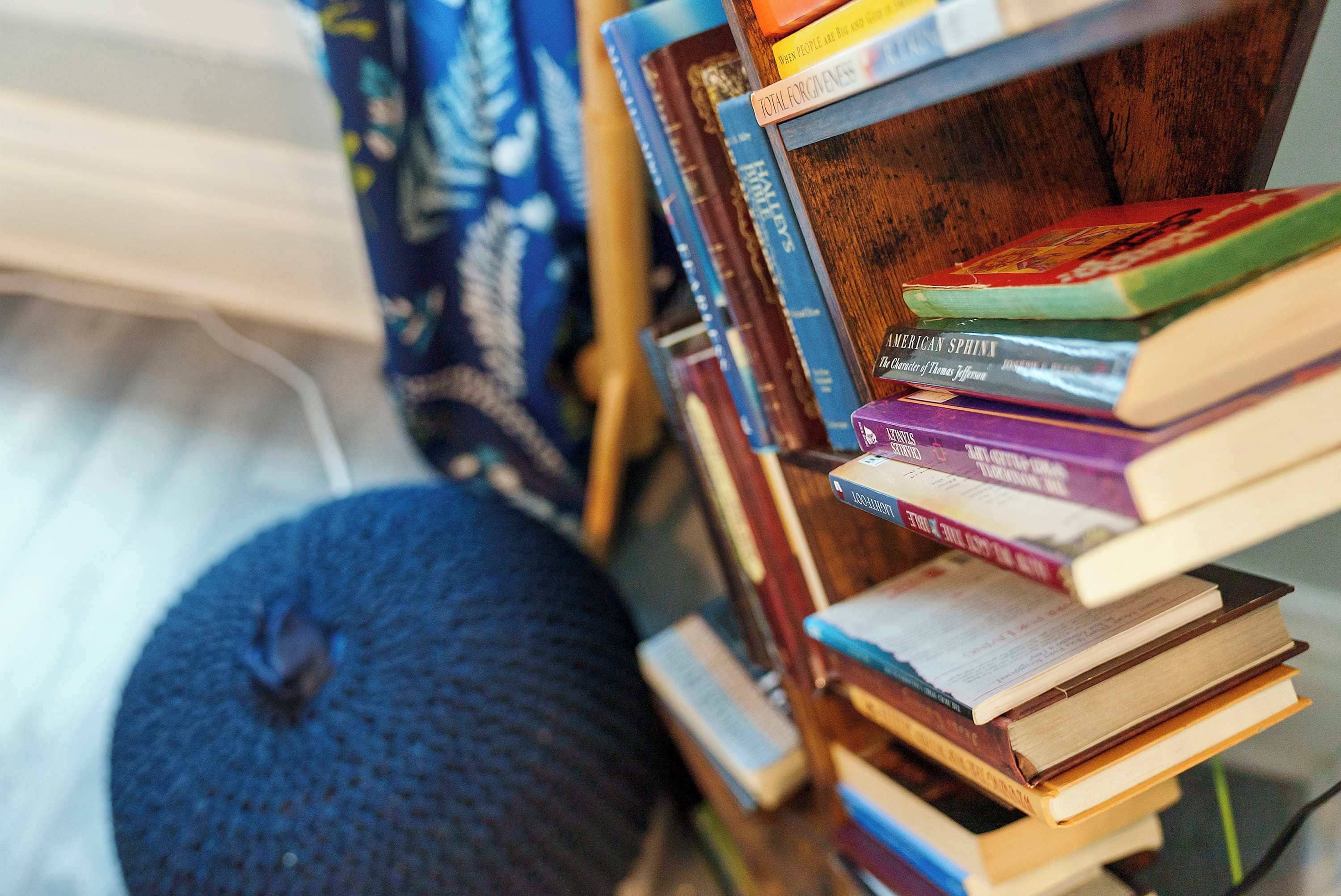 A stack of books on a wooden shelf.