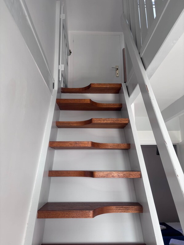 Un escalier avec des marches en bois et des murs blancs.