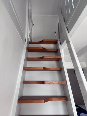 Eine Treppe mit Holzdielen und weißen Wänden.