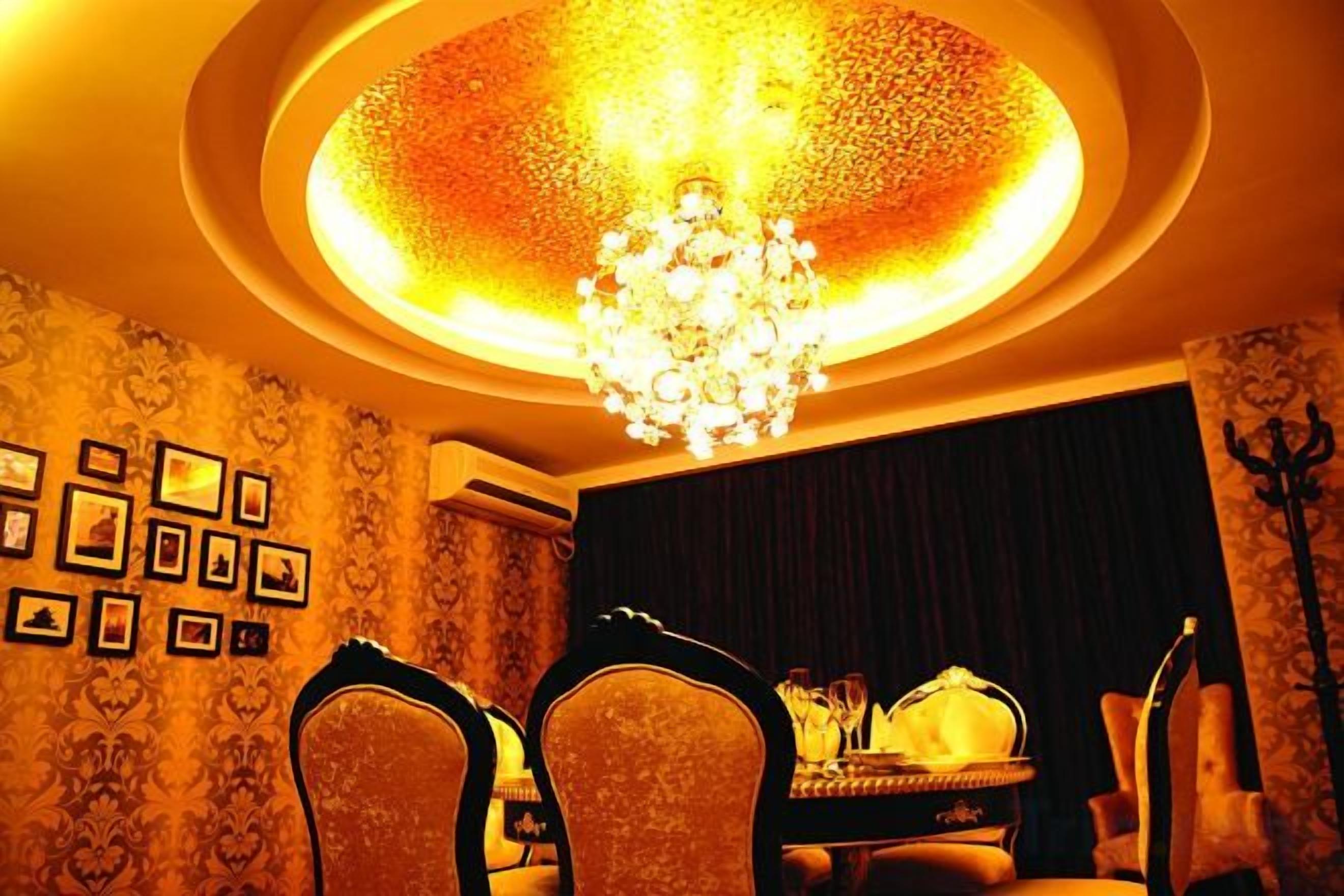 Uma sala de jantar com lustre, cadeiras e mesa posta para dois.