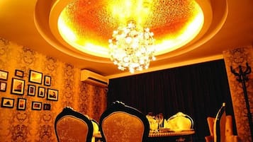 Uma sala de jantar com lustre, cadeiras e mesa posta para dois.