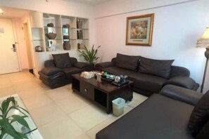 A living room with a sofa set, a coffee table, and a bookshelf.