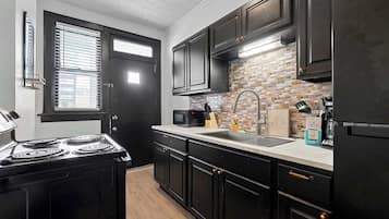 Apartamento, várias camas, varanda, vista para o jardim (Merion Village Residences 1166) | Cozinha privada | Geladeira, micro-ondas, fogão, cooktop