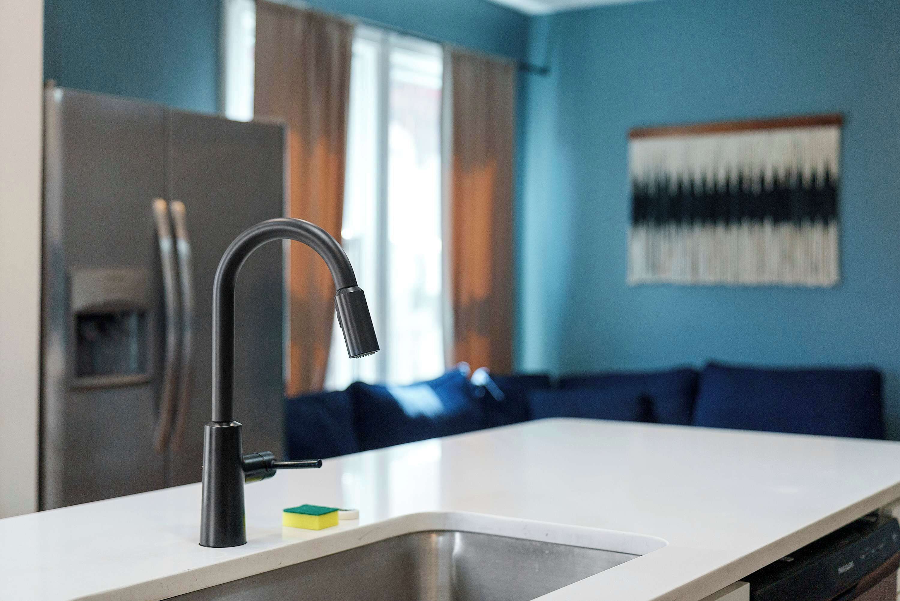 A modern kitchen with a stainless steel sink, a faucet, and a dishwasher.
