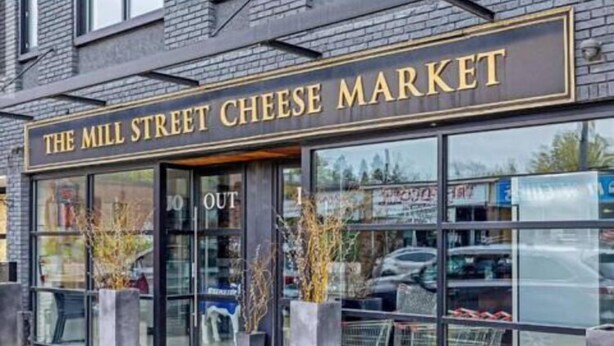 Une devanture de magasin avec une enseigne indiquant : « Le marché fromager de Mill Street ».