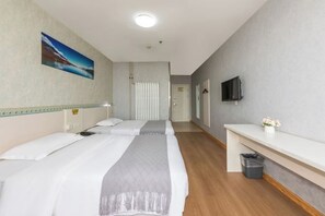 A hotel room with two beds, a TV, a small desk, and a trash bin. - 7 Days Inn Tianjin Jintang Main Road Pipe Company Light Rail Station (Tianjin)