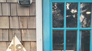 A turquoise door with a window, a wooden shingle wall, and a number '18' sign. - Panoramic Cape Cod Bay Views with Private Sandy Beach (Plymouth)