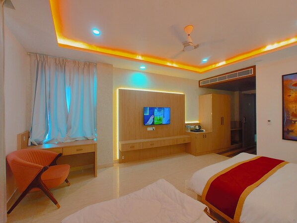 Una habitación de hotel con cama, escritorio, silla, televisor y armario.