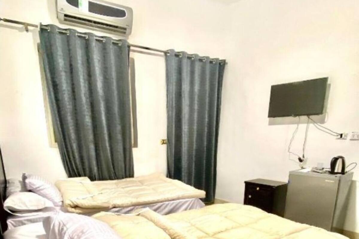 A bedroom with a bed, a television, and a heater.