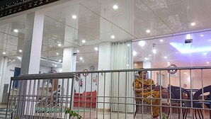 A modern building with a glass facade, multiple floors, and a staircase leading to an upper level. - The Bodhgaya Hotel School (Bodh Gaya)