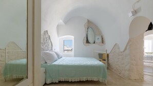 A bedroom with a bed, a window, and a mirror. - Petra Suite Ostuni by Wonderful Italy (Ostuni)