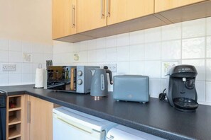 A modern kitchen with a toaster, kettle, and coffee maker on the counter.