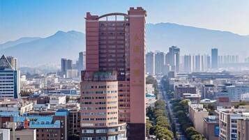 A high-rise building with multiple floors, surrounded by other buildings and a clear sky.