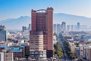 Un edificio de gran altura con varios pisos, rodeado de otros edificios y un cielo despejado.