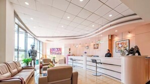 A modern lobby with a reception desk, seating area, and large windows. - Longma Ginza Hotel (Yuxi)