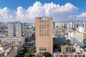 A high-rise building with multiple floors, surrounded by other buildings in an urban setting. - Longma Ginza Hotel (Yuxi)