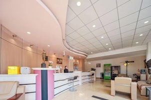 A reception area with a curved counter, seating, and a ceiling with recessed lighting.