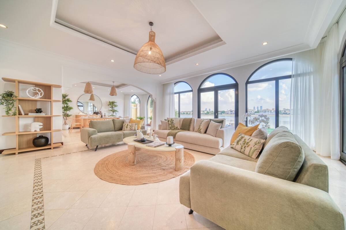 A spacious living room with a large window, a round coffee table, and a sofa.