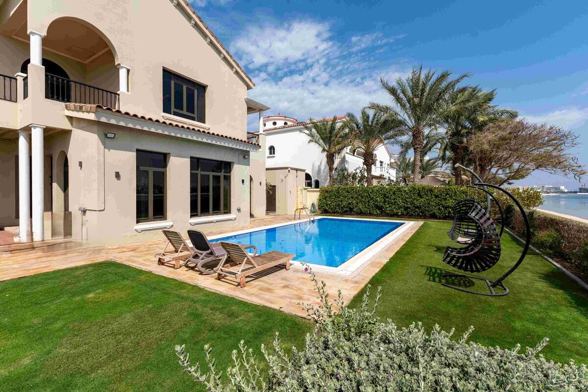 A house with a swimming pool, a balcony, and a view of the sea.