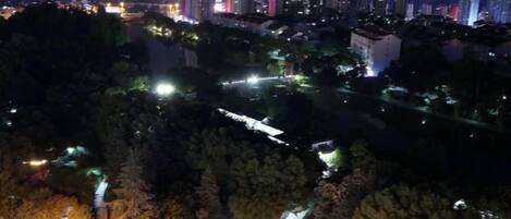 A nighttime cityscape with illuminated buildings and a river.