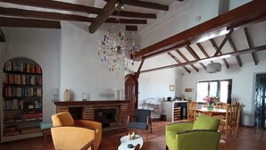 Un salon spacieux doté d’une cheminée, d’une bibliothèque et d’un coin repas avec des meubles en bois.