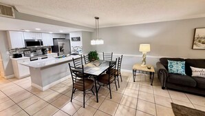 A modern kitchen with white cabinetry, a central island, and stainless steel appliances.