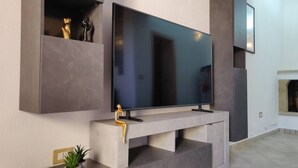 A modern living room with a large flat-screen TV mounted on a minimalist console.
