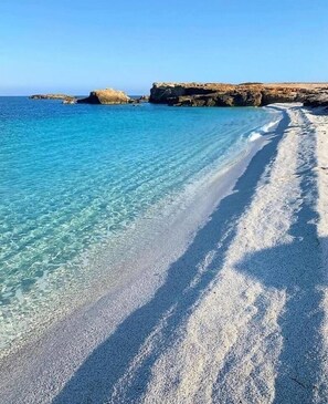 Una playa con aguas turquesas cristalinas y una orilla arenosa.