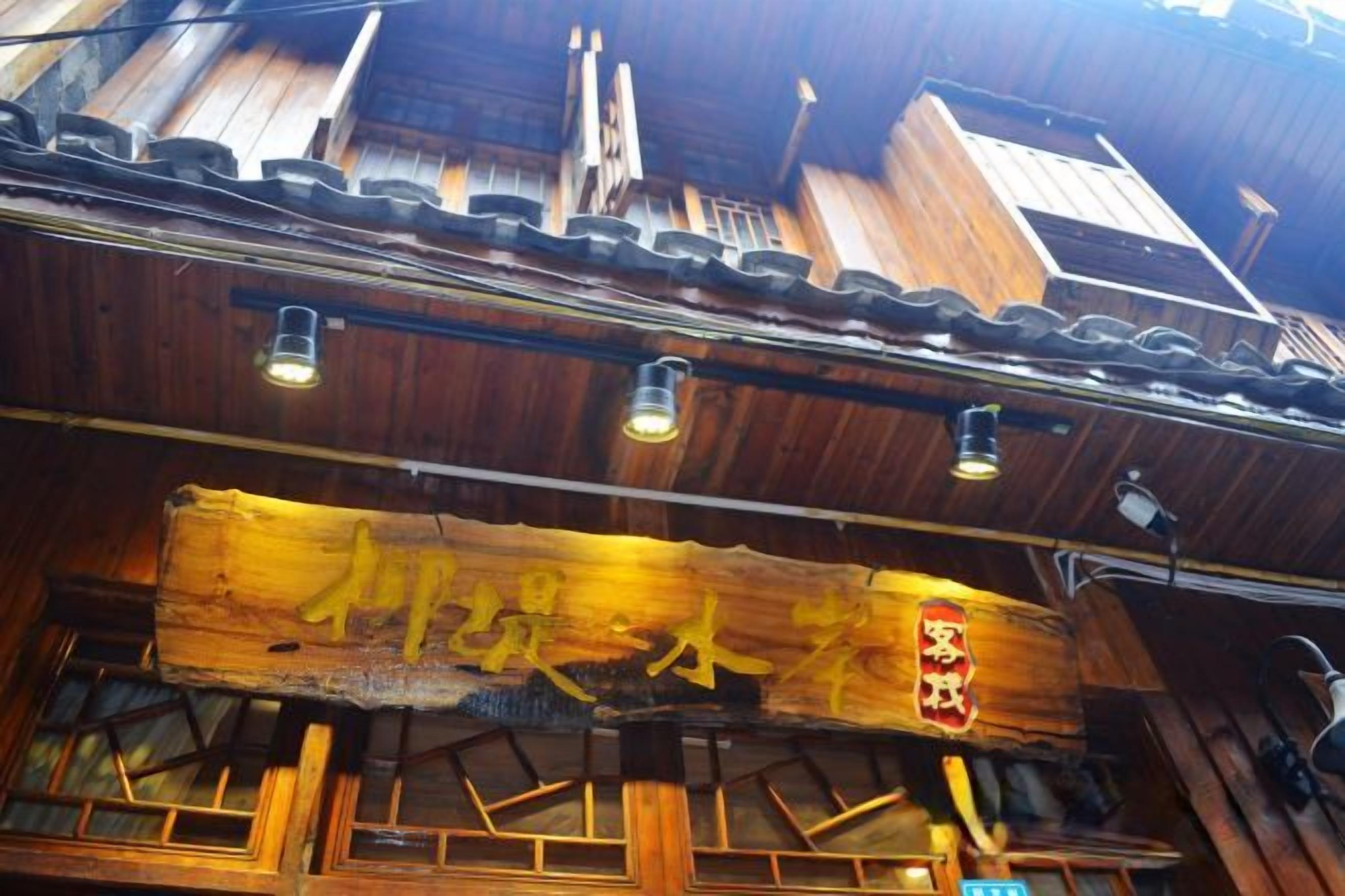 A traditional wooden building with a signboard and a sloped roof.