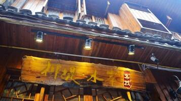 A traditional wooden building with a signboard and a sloped roof.