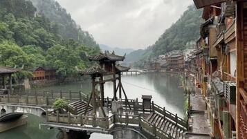 A traditional wooden bridge over a river, surrounded by buildings with traditional architecture.