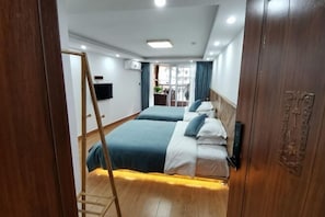 A hotel room with two beds, a wooden wardrobe, a television, and a window with curtains. - Fengyuanju Inn (Fenghuang County)