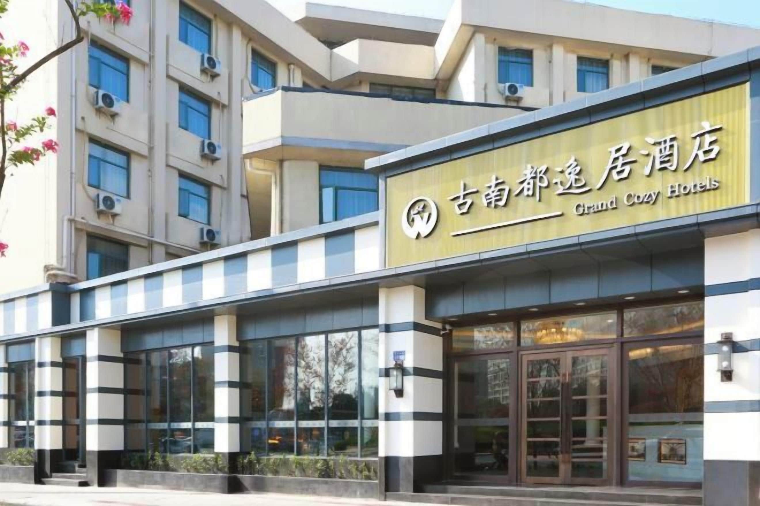 A hotel building with a sign that reads 'Grand Cozy Hotels.'