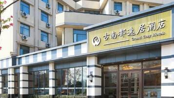 A hotel building with a sign that reads 'Grand Cozy Hotels.'