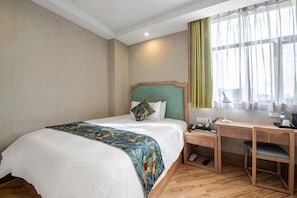 A hotel room with a bed, desk, chair, and a window with curtains. - Grand Cozy Hotel (Yangzhou Dongguan Street) (Yangzhou)
