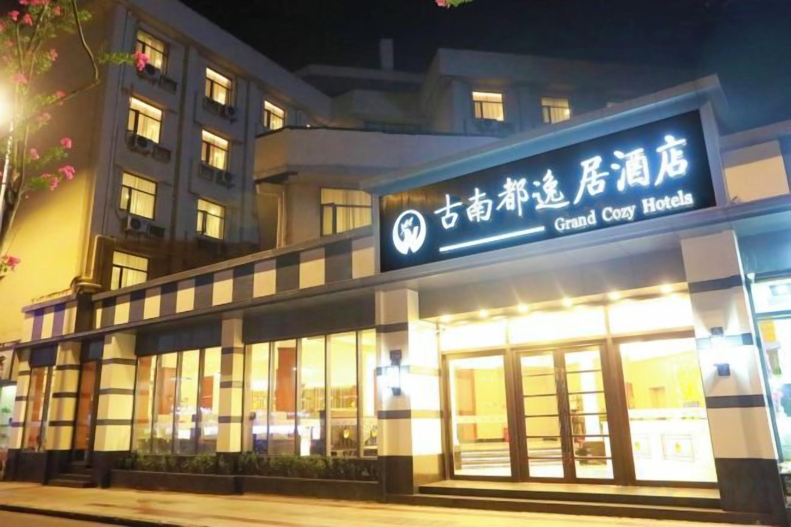 Un hotel con un letrero llamativo, ventanas amplias y una fachada bien iluminada.