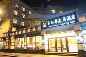 Un hotel con un letrero llamativo, ventanas amplias y una fachada bien iluminada.